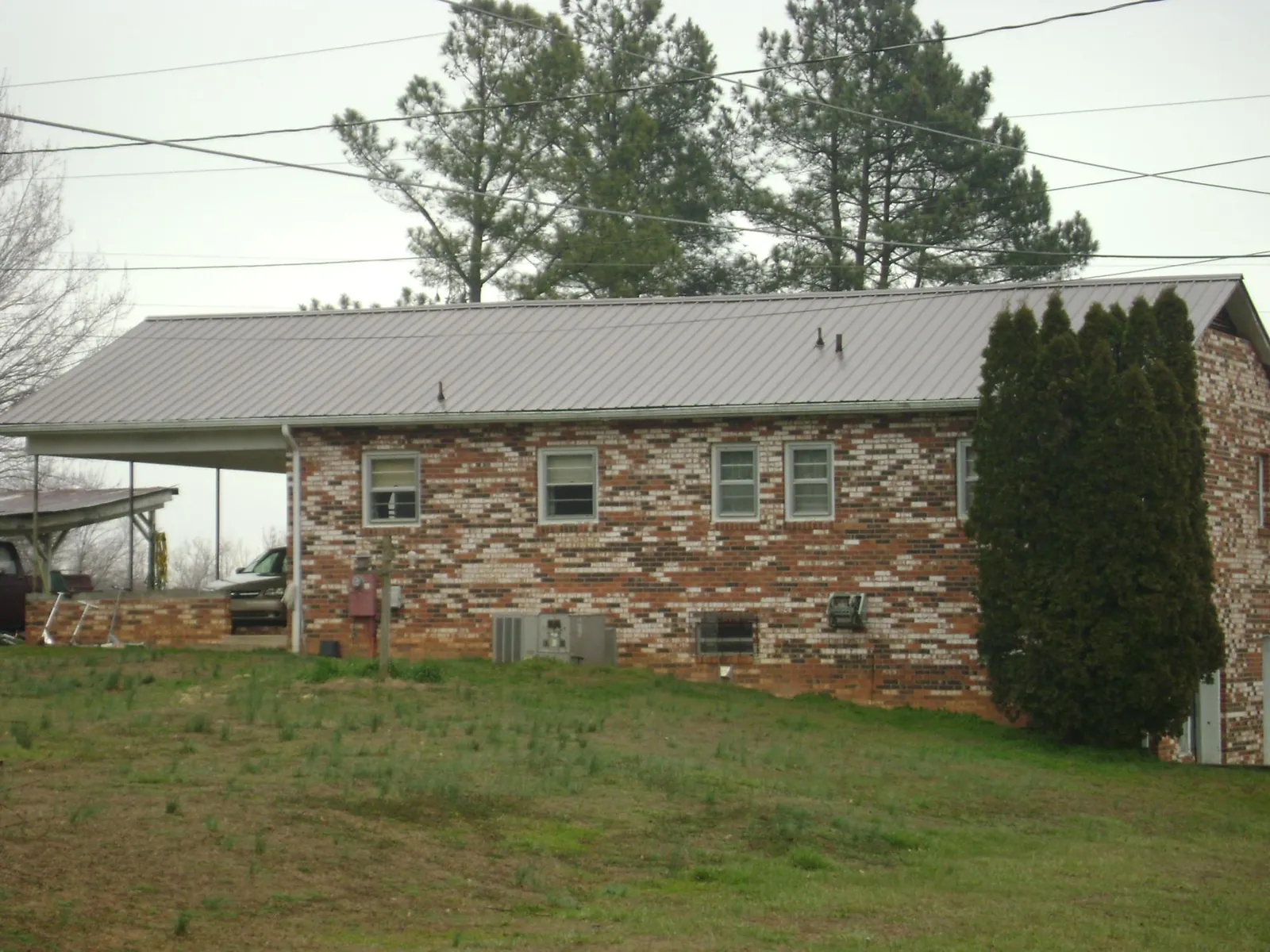 Gray metal roof on a brick split level home with a carport in Moorhead